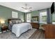 Comfortable bedroom featuring an elegant ceiling fan, plush bedding, and natural light at 11142 Spring Point Cir, Riverview, FL 33579