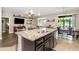 Kitchen island with barstool seating, granite countertops, and open view to the living and dining areas at 11142 Spring Point Cir, Riverview, FL 33579