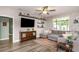 Cozy living room with a large sectional sofa, floating shelves, and hardwood floors at 11142 Spring Point Cir, Riverview, FL 33579