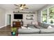 Comfortable living room features a large gray sectional, floating shelves, and a ceiling fan at 11142 Spring Point Cir, Riverview, FL 33579