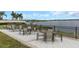 Community patio area with chairs and tables offer amazing lake views for residents to gather and relax at 11142 Spring Point Cir, Riverview, FL 33579