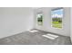 Sunlit bedroom with two windows, plush carpet and neutral paint at 11447 Shoreline Trl, Parrish, FL 34219