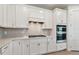Close up view of a kitchen featuring all-white cabinetry, stainless appliances, and tiled backsplash at 11447 Shoreline Trl, Parrish, FL 34219