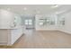 Open living space features wood floors, neutral paint, and is located next to the kitchen with backyard access at 11447 Shoreline Trl, Parrish, FL 34219