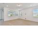 Bright living area with wood flooring, windows, and sliding glass door access to the screened-in patio at 11447 Shoreline Trl, Parrish, FL 34219
