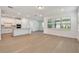 Living area with wood floors adjacent to kitchen with lots of natural light and backyard views at 11447 Shoreline Trl, Parrish, FL 34219
