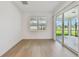 Open living area with wood flooring, a large window, and access to the backyard patio at 11447 Shoreline Trl, Parrish, FL 34219
