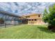 Spacious backyard featuring a screened pool, lush green lawn, and charming outdoor seating at 12610 Eagles Entry Dr, Odessa, FL 33556