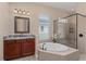 Luxurious bathroom featuring a soaking tub, glass-enclosed shower, and elegant vanity at 12610 Eagles Entry Dr, Odessa, FL 33556