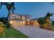 Beautiful two-story home with well-manicured lawn, mature palms, and brick paver driveway at 12610 Eagles Entry Dr, Odessa, FL 33556