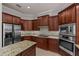 Gourmet kitchen showcasing dark wood cabinets, granite countertops, and stainless steel appliances at 12610 Eagles Entry Dr, Odessa, FL 33556