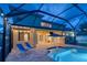 A backyard pool patio with lounge chairs with a screened enclosure at 12610 Eagles Entry Dr, Odessa, FL 33556