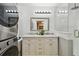 Bright bathroom features a double sink vanity, washer dryer, and framed mirror at 130 41St Ne Ave, St Petersburg, FL 33703
