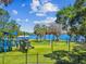 A colorful and fun playground with green turf, a view to the water, and blue skies at 130 41St Ne Ave, St Petersburg, FL 33703