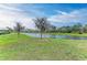 A serene backyard view featuring a tranquil lake and lush green grass at 13034 Bliss Loop, Bradenton, FL 34211