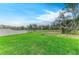 Lush backyard with vibrant green grass, a white fence, and mature trees, perfect for outdoor activities and relaxation at 13034 Bliss Loop, Bradenton, FL 34211