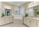 Elegant bathroom with double vanities, soaking tub, and updated lighting fixtures at 13034 Bliss Loop, Bradenton, FL 34211