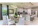 Modern dining room featuring a glass table, white chairs, gray walls, and contemporary lighting at 13034 Bliss Loop, Bradenton, FL 34211