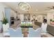 Open dining area with a glass table, views of kitchen, stylish chandelier, and integrated appliances at 13034 Bliss Loop, Bradenton, FL 34211