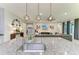 Open-concept kitchen featuring granite countertops, stainless steel faucet, and modern pendant lighting at 13034 Bliss Loop, Bradenton, FL 34211