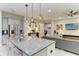 Open concept kitchen with island, granite countertops, pendant lighting, and stainless steel appliances at 13034 Bliss Loop, Bradenton, FL 34211