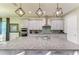 Large kitchen island featuring granite countertops, pendant lighting, stainless steel appliances, and gray cabinetry at 13034 Bliss Loop, Bradenton, FL 34211
