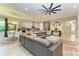 Open-concept living room featuring a gray leather sectional, tile floors, and views of the kitchen at 13034 Bliss Loop, Bradenton, FL 34211