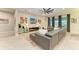 Spacious living room featuring a modern ceiling fan, television, contemporary decor, and gray tile floors at 13034 Bliss Loop, Bradenton, FL 34211