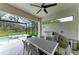 Spacious screened-in patio with a built-in outdoor kitchen, grill, dining table, and scenic pool views at 13034 Bliss Loop, Bradenton, FL 34211