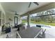 Inviting screened patio with comfortable seating, dining area, ceiling fan, and views of the pool and natural landscape at 13034 Bliss Loop, Bradenton, FL 34211