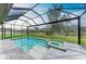 Sparkling in-ground pool and spa with a screened enclosure, providing a private oasis with beautiful green views at 13034 Bliss Loop, Bradenton, FL 34211
