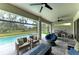 Covered patio with comfortable seating, an outdoor kitchen, pool, and picturesque views of the backyard at 13034 Bliss Loop, Bradenton, FL 34211