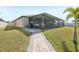 Wide view of backyard with a covered patio, screened lanai, and green grass at 14413 Seattle Slew Ln, Ruskin, FL 33573