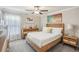 A bright bedroom with a wood frame bed, dresser, and ceiling fan at 14413 Seattle Slew Ln, Ruskin, FL 33573