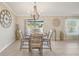 Bright dining area with a round table, chandelier, and natural light from the sliding glass doors at 14413 Seattle Slew Ln, Ruskin, FL 33573