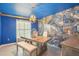 Dining room featuring a blue ceiling and accent wall paired with a modern chandelier at 14413 Seattle Slew Ln, Ruskin, FL 33573