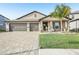 Charming single-story home featuring a three-car garage, stone driveway, and a neatly manicured front lawn at 14413 Seattle Slew Ln, Ruskin, FL 33573
