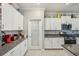 Charming kitchen with stylish granite countertops and white cabinetry; a pantry sits near the stovetop at 14413 Seattle Slew Ln, Ruskin, FL 33573