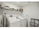 Efficient laundry room equipped with modern washer, dryer, and storage shelving at 14413 Seattle Slew Ln, Ruskin, FL 33573