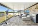 Expansive covered patio with outdoor seating, a mini refrigerator, and views of the backyard at 14413 Seattle Slew Ln, Ruskin, FL 33573