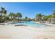 Resort-style pool with palm trees and ample seating for relaxing by the water at 14413 Seattle Slew Ln, Ruskin, FL 33573