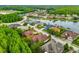 An aerial view of the homes within a lakeside community with mature trees lining the street at 15045 Wind Whisper Dr, Odessa, FL 33556