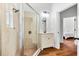 Bathroom showcasing a glass shower and a stylish vanity with modern fixtures and wood floors at 15045 Wind Whisper Dr, Odessa, FL 33556
