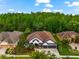 Aerial view of home showcasing impeccable landscaping, mature trees and three-car garage at 15045 Wind Whisper Dr, Odessa, FL 33556