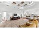 Open-concept living room featuring plush seating and an elegant coffered ceiling with kitchen view at 15045 Wind Whisper Dr, Odessa, FL 33556