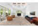 Large living room featuring coffered ceilings, built-in shelving, large windows, and access to the outdoors at 15045 Wind Whisper Dr, Odessa, FL 33556