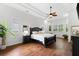 Bright main bedroom featuring a ceiling fan, hardwood floors, two windows, and dark wood furniture at 15045 Wind Whisper Dr, Odessa, FL 33556