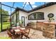 The outdoor kitchen and dining area offers a wonderful space to grill and entertain while enjoying the outdoors at 15045 Wind Whisper Dr, Odessa, FL 33556