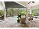 Covered patio space with stylish seating overlooking the screened swimming pool at 15045 Wind Whisper Dr, Odessa, FL 33556