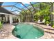 Tranquil screened pool area surrounded by tropical plants and comfortable lounge seating at 15045 Wind Whisper Dr, Odessa, FL 33556